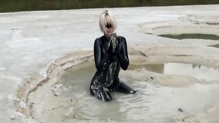 Super Hot Blond Girl in Black Latex Catsuit + High Heels and Sunglasses Bathes in the Mud - Mud Bath