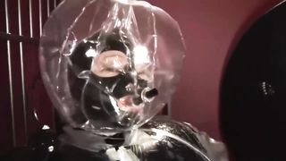 Blonde Girl in Black Latex Catsuit Full Encased in Inflatable Rubber and Full Body Plastic Suit